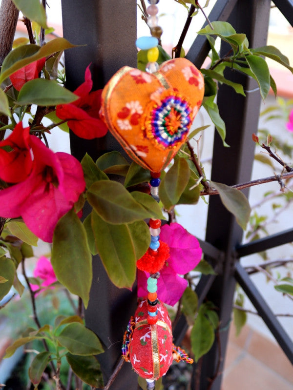 COLGADOR DE CORAZONES EN TELA.
Está elaborado con tela.
Es un tira decorativa donde caen piezas coloridas de corazón en tela.
Se intercalan con pequeñas cuentas y pompones, en su extremo tiene una campana.
Medidas aproximadas 100 cm.
ENVÍO GRATIS.