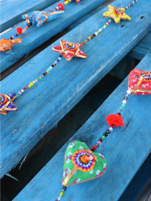 Está elaborado con tela.
Es un tira decorativa donde caen cinco piezas coloridas con figuras de elefantes.
Se intercalan con pequeñas cuentas y pompones, en su extremo tiene una campana.
Medidas aproximadas 100 cm.
ENVÍO GRATIS SIN PEDIDO MÍNIMO.