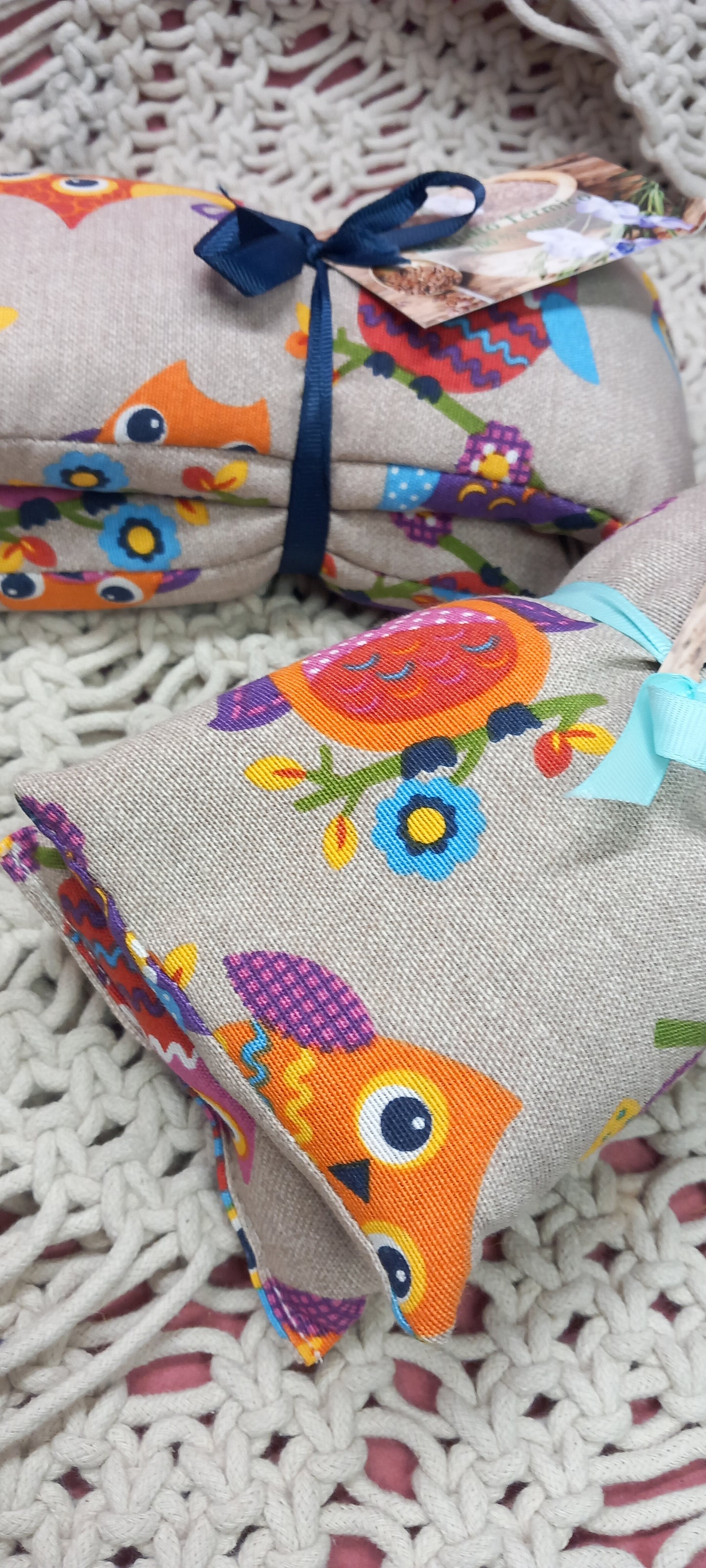 Saco térmico terapeútico de búhos en colores sobre fondo de grises.