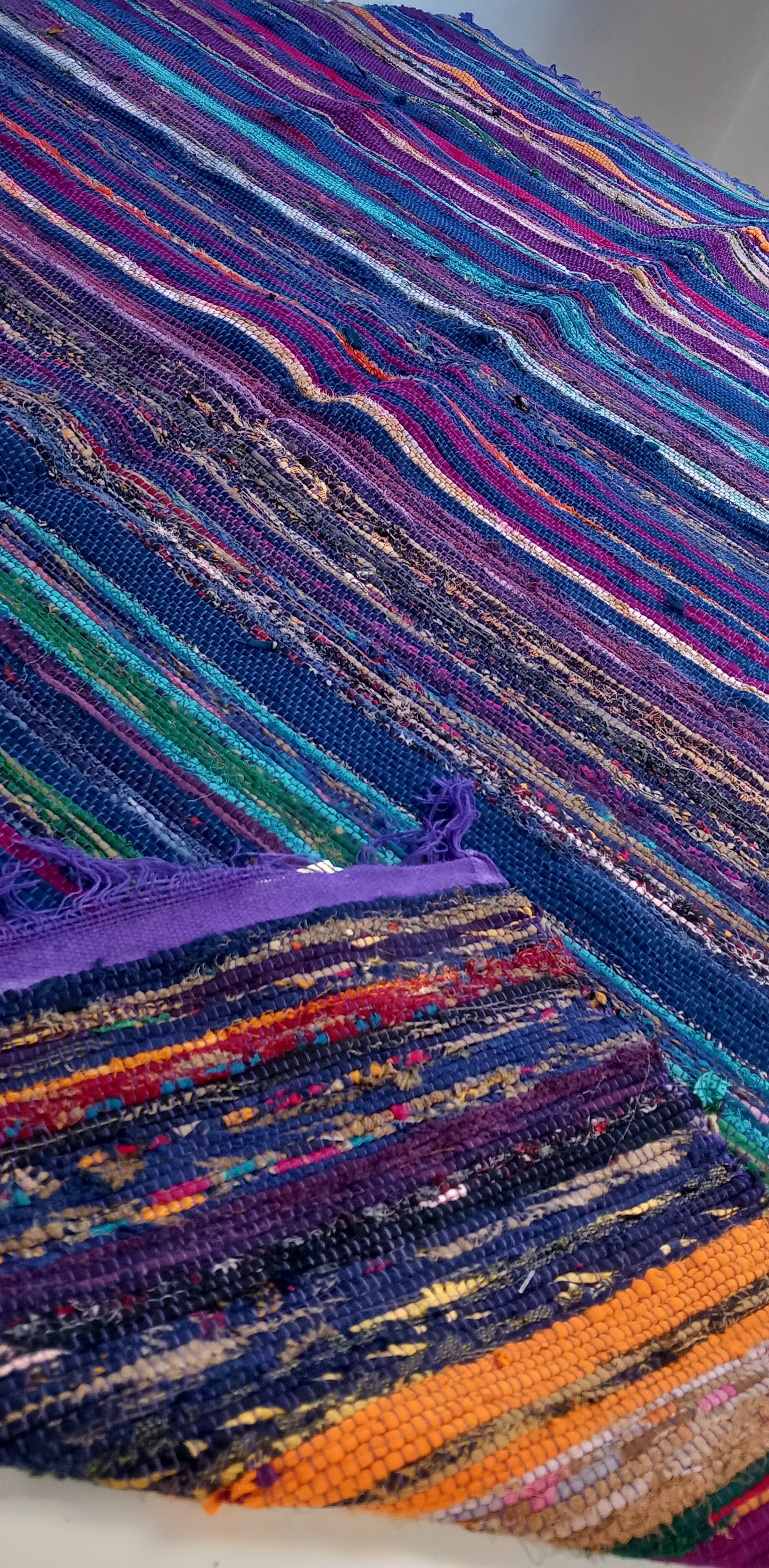 Una explosión de color, textura y tradición en una sola pieza. La jarapa multicolor de 100x200 cm está elaborada artesanalmente con retales de algodón tratados con tintes naturales, lo que da como resultado una alfombra única, vibrante y cargada de carácter. Su diseño mezcla tonos de forma armónica, creando un efecto visual atractivo y cálido. Además de usarse como alfombra, es perfecto como tapiz de pared, cubrecama o para renovar el estilo de muebles y sofás.