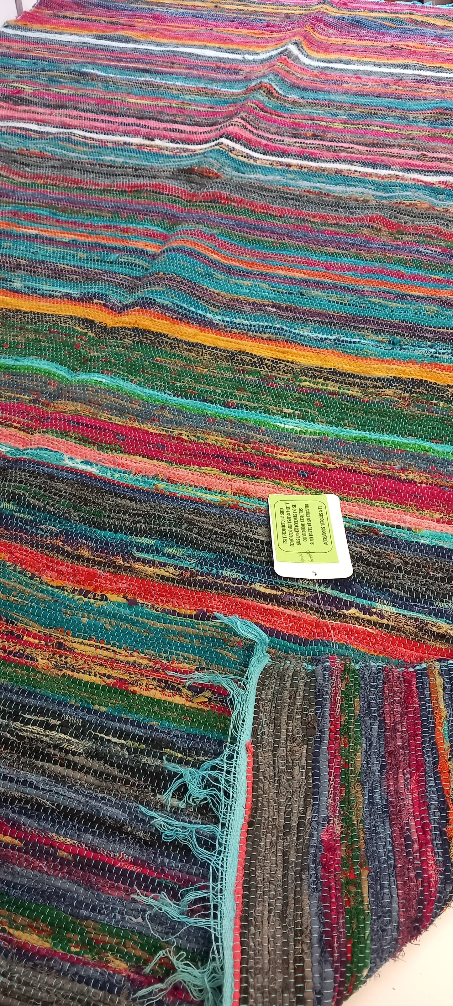 Una explosión de color, textura y tradición en una sola pieza. La jarapa multicolor de 100x200 cm está elaborada artesanalmente con retales de algodón tratados con tintes naturales, lo que da como resultado una alfombra única, vibrante y cargada de carácter. Su diseño mezcla tonos de forma armónica, creando un efecto visual atractivo y cálido. Además de usarse como alfombra, es perfecto como tapiz de pared, cubrecama o para renovar el estilo de muebles y sofás.