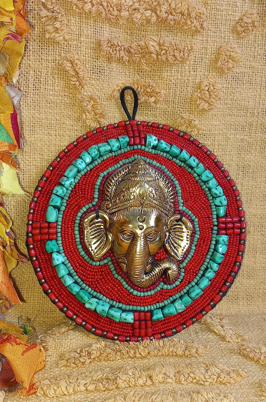 Pieza decorativa de metal con piedras y minerales con forma de redonda, trabajada en metal y con la imagen de Ganesha en relieve. Este modelo artesanal une simbolismo y estética, siendo ideal para dar un toque espiritual y exótico a cualquier rincón. Perfecto como artículo decorativo con historia, ideal para ambientes con clientela amante del arte oriental o de la cultura india.