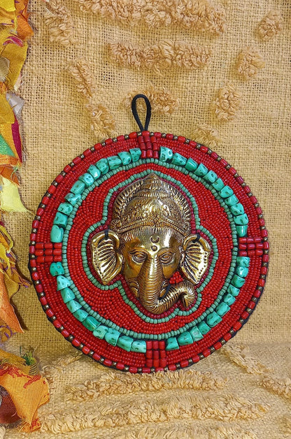 Pieza decorativa de metal con piedras y minerales con forma de redonda, trabajada en metal y con la imagen de Ganesha en relieve. Este modelo artesanal une simbolismo y estética, siendo ideal para dar un toque espiritual y exótico a cualquier rincón. Perfecto como artículo decorativo con historia, ideal para ambientes con clientela amante del arte oriental o de la cultura india.
