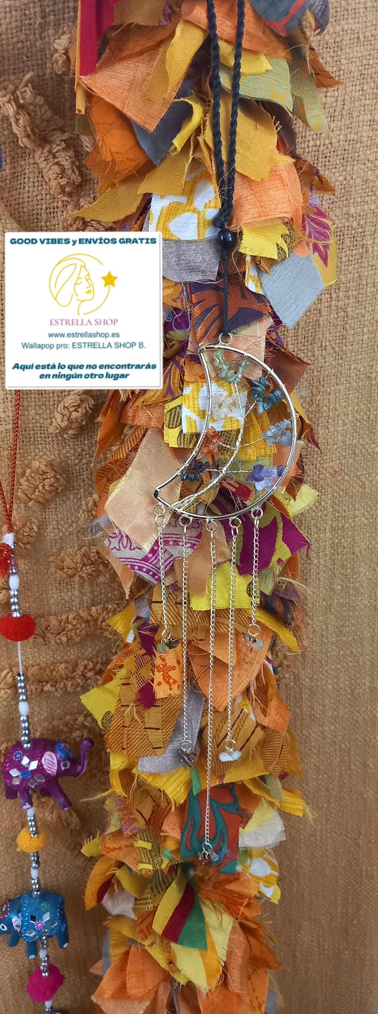 Una pieza armoniosa para el alma y los sentidos. Este colgador móvil de viento combina minerales y metal en un diseño artesanal con gran carga estética y natural. Su luna central tallada con árbol y minerales sostiene varios tubos de cobre y minerales decorativos con piedras naturales sin pulir reales colgantes que, al moverse con la brisa, producen un ambiente suave y relajante. Una pieza ideal para llenar de calma y energía positiva cualquier espacio, tanto interior como exterior.