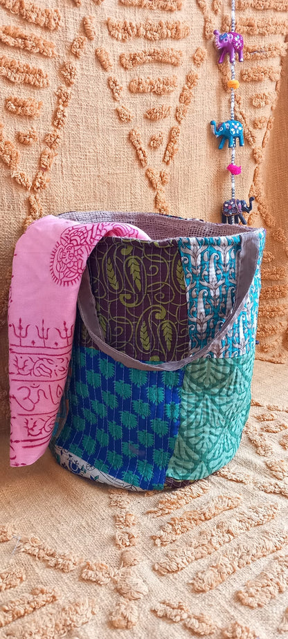 El Cesto Wild Saree es una pieza artesanal única que combina funcionalidad, sostenibilidad y estilo en un diseño versátil. Confeccionado con telas sedadas recicladas de saree y yute, cada cesto es irrepetible gracias a sus vibrantes estampados elaborados con la técnica de patchwork. Con unas medidas de 25x30 cm, es ideal para usarlo como bolso con un toque bohemio o como elemento decorativo en el hogar, aportando color, personalidad y un aire auténtico de artesanía india.