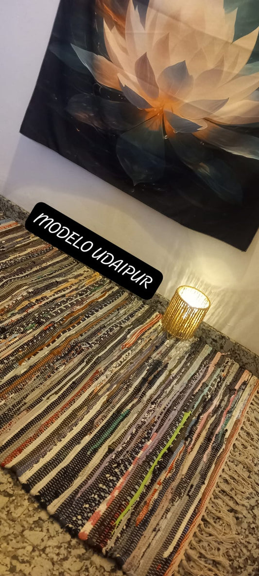 Una explosión de color, textura y tradición en una sola pieza. La alfombra multicolor de 150x80 cm está elaborada artesanalmente con retales de algodón tratados con tintes naturales, lo que da como resultado una alfombra única, vibrante y cargada de carácter. Su diseño mezcla tonos de forma armónica, creando un efecto visual atractivo y cálido. Además de usarse como alfombra, es perfecto como tapiz de pared, cubrecama o para renovar el estilo de muebles y sofás.