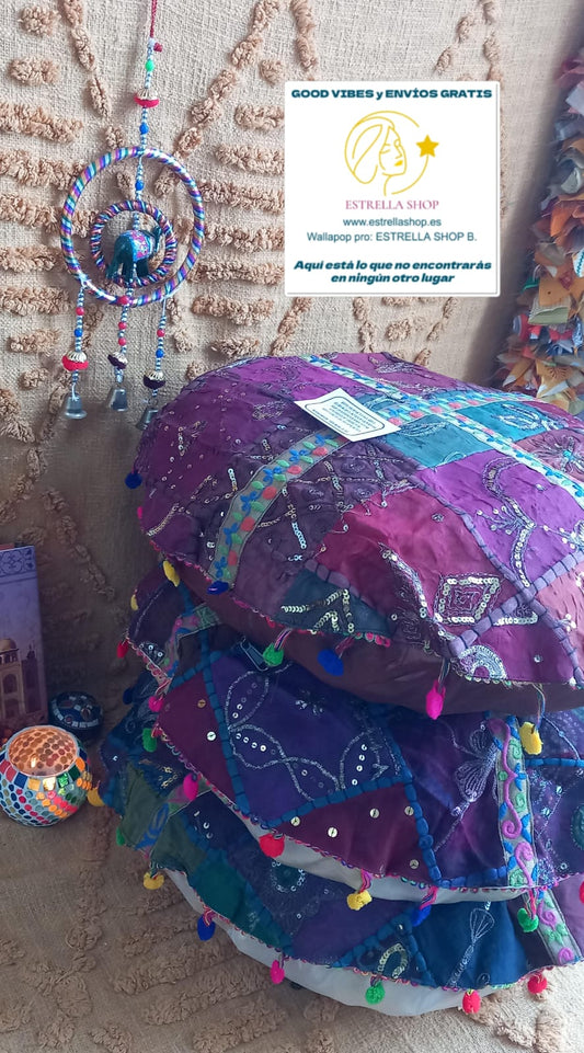 Una pieza que brilla con luz propia y llena de personalidad en cualquier espacio. El zafú patchwork redondo de 50 cm de diámetro aprox. está elaborado artesanalmente a partir de retales decorados con bordados, lentejuelas e hilos metálicos en tonos dorados. Cada unidad es diferente, con ribetes únicos y una parte posterior lisa para mayor versatilidad. Su tamaño generoso lo convierte en un asiento cómodo, un zafú de meditación o un elemento decorativo central en ambientes bohemios y étnicos.
