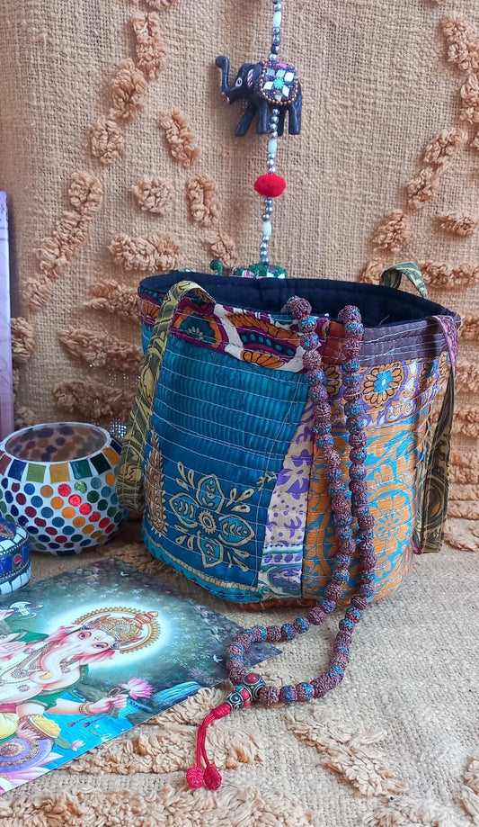 Un cesto tipo bolsa llena de color y espíritu boho que aporta alegría y diferenciación a tu selección de complementos.
Cada pieza es original y exclusiva, creada a partir de telas sedadas de sari mediante técnicas de suprareciclaje.
Un accesorio con alma, pensado para tiendas que apuestan por productos únicos y con historia.
Su diseño patchwork convierte cada cesto en un reclamo visual irresistible.
Cómodo y ligero, ideal para ofrecer un complemento práctico con alto valor artesanal.
Una propuesta especial 