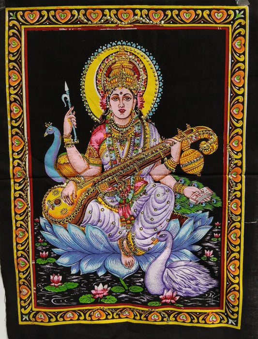 Un homenaje textil a la espiritualidad y la tradición hindú. El tapiz Dioses de 40x58 cm está elaborado con tela estampada y adornado con vibrantes colores y lentejuelas que aportan luz y profundidad. Sobre un fondo negro destacan figuras sagradas como Saraswati, sentada sobre el loto, símbolo de la pureza del alma y del conocimiento que florece desde lo espiritual. Saraswati es la energía divina de la sabiduría, la educación, la música, la palabra y la creatividad consciente.