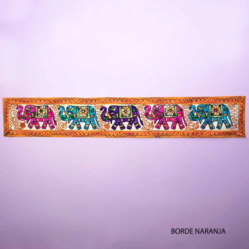 Con unas medidas de 31x180 cm, es perfecto para colgar en paredes, cubrir muebles o incluso utilizar como un elegante camino de mesa. Su diseño presenta cinco elefantes bordados en colores luminosos, creando un efecto visual impactante y alegre. Cada elefante, meticulosamente trabajado, refleja la maestría artesanal de los bordadores, aportando un toque cultural y auténtico a tu decoración.